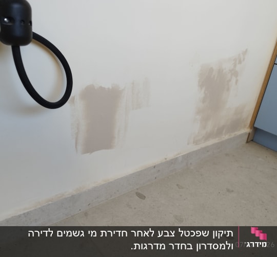 קיר עם תיקוני טיח ליד ארון כחול